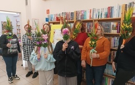 Uczestnicy warsztatów pozują do zdjęcia ze swoimi palmami