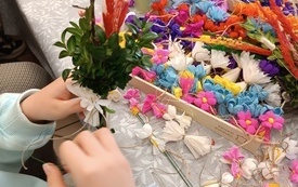 Stół z kolorowymi kwiatami służącymi do wyrobu palm