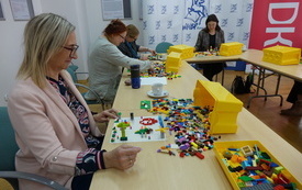 Bibliotekarki tworzą prace z klock&oacute;w lego. 