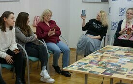 Kobiety bibliotekarki trzymające w rękach karty do gry. 