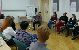 Mężczyzna prowadzący szkolenie pisze na flipcharcie. 