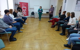 Bibliotekarki siedzące w kręgu podczas powitania dyrektor biblioteki.
