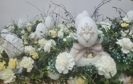 Kilka stroików skomponowanych z kwiatów i jajek.