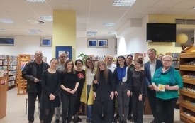 Grupa uczestników spotkania pozuje do wspólnego zdjęcia