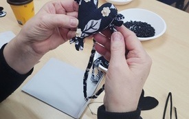 Naszyjnik z sercem trzymany w rękach.