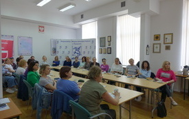 Sala ze stołami, przy których siedzą bibliotekarki.