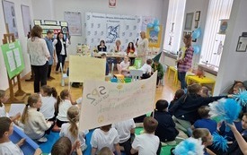 Kibicujące dzieci z pomponami i transparentami.