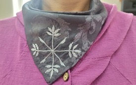 Chusta z wyszytym wzorem na szyi kobiety.