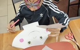 Dziewczynka z rysunkiem motyla na twarzy.