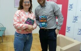 Gość spotkania pozuje do wspólnego zdjęcia z młodą kobietą.