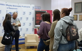 Gość spotkania podczas składania autografów.