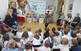 bibliotekarki z rysunkami na środku sali. 
