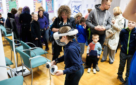 Stanowisko z googalmi VR, dzieci czekają w kolejce do gry.