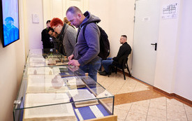 Odwiedzający oglądają wystawę starodruków.