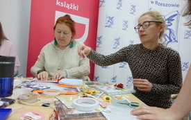 Dwie kobiety przy pracy nad notatnikiem.