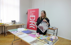 Bibliotekarka przy stanowisku z materiałami plastycznymi.