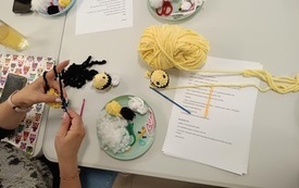 Na stoliku materiały potrzebna do wykonania robótki na szydełku.