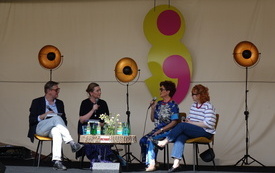 Przy stoliku z napojami cztery rozmawiające osoby.