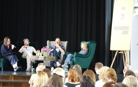 Na scenie cztery osoby siedzące w fotelach. Przed sceną zgromadzona publiczność.