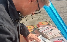 Pisarz podpisujący książki.