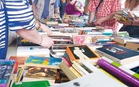 Czytelnicy szukający książek podczas kiermaszu.