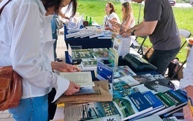 Kobieta przeglądająca ksiażki na stoisku wydawnictwa.