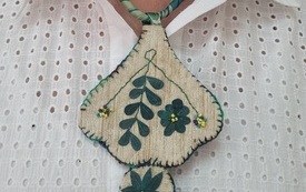 Naszyjnik zdobi szyję kobiety.