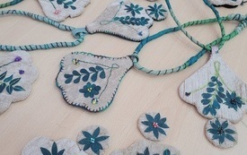 Kilkanaście naszyjników rozłożonych.