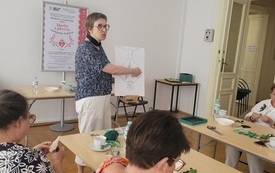 Kobieta na środku sali przemawia. 