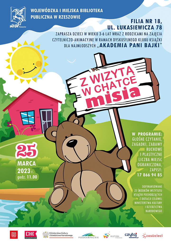 Pluszowy miś siedzi na zielonej trawie, w tle za nim różowa chatka