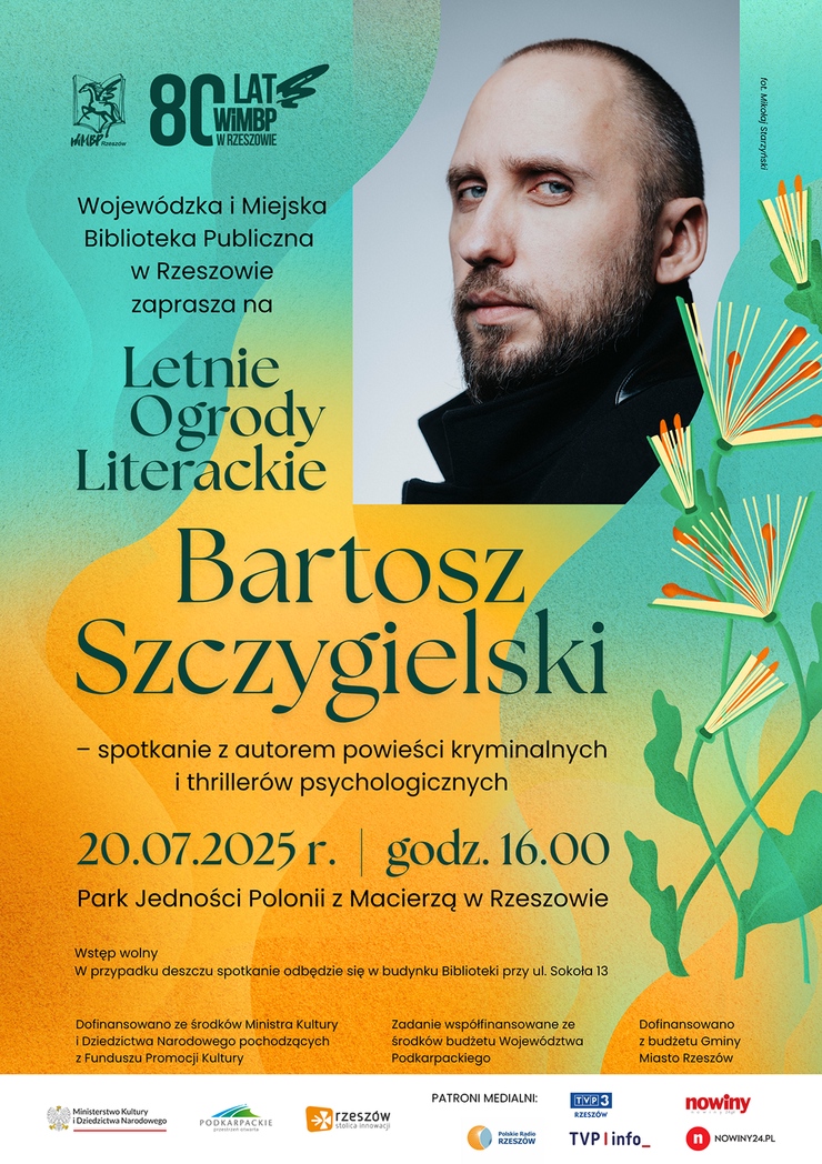 Mężczyzna z zarostem w czarnym ubraniu obok książki kwiaty